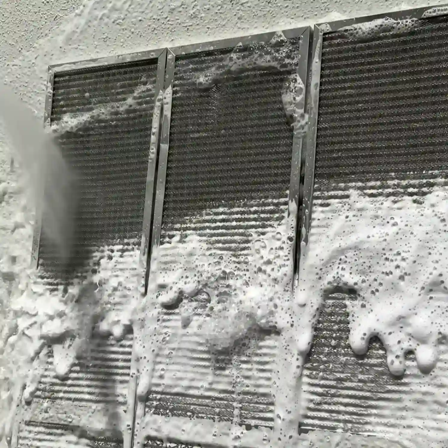 利用高壓水柱和清潔劑清洗冷氣機濾網